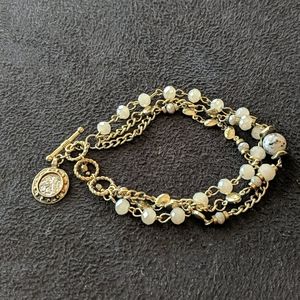 Gold bracelet with coin accent and cream beads
